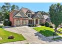 Attractive brick home with a spacious driveway and perfectly manicured front lawn at 4050 Bonnett Creek Ln, Hoschton, GA 30548