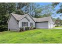 View of home, attached garage and well maintained lawn and landscaping at 112 Laguna Springs Dr, Woodstock, GA 30188