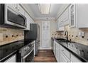 Updated kitchen showcasing stainless steel appliances, modern cabinets, and sleek black countertops at 1120 Highland Bluff Se Dr, Atlanta, GA 30339