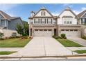 Beautiful townhome featuring a two-car garage, brick accents, well-maintained lawn, and inviting curb appeal at 2169 Lanier Harbor Pt, Buford, GA 30518