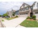 Attractive townhome with a two-car garage, landscaping, and a well-maintained lawn at 2169 Lanier Harbor Pt, Buford, GA 30518