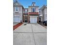 Charming townhome showcases a brick front, single-car garage, and a well-maintained driveway at 2189 Executive Dr, Duluth, GA 30096