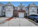 Charming townhome showcases a brick front, single-car garage, and a well-maintained driveway at 2189 Executive Dr, Duluth, GA 30096