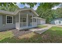 Close-up of a charming home's entrance with a covered porch, white columns, and gray siding at 3181 Woodbridge Ct, Snellville, GA 30039