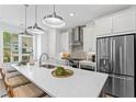 Bright kitchen features a quartz countertop island with bar stools and stainless steel appliances at 626 Skytop Dr # 159, Cumming, GA 30040