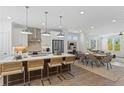 Modern kitchen featuring an island with bar seating, stainless appliances, and an open layout into dining and living areas at 626 Skytop Dr # 159, Cumming, GA 30040
