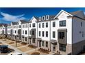 Row of new townhomes with brick accents, gray roof and trimmed green lawns, showcasing street appeal at 621 Silva St # 124, Cumming, GA 30040