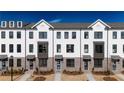 Attractive new construction townhomes with white exteriors, contrasting brick, and manicured front lawns at 621 Silva St # 124, Cumming, GA 30040