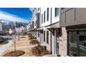 Street-level view of new townhomes featuring brick exteriors, individual entrances, and mature landscaping at 621 Silva St # 124, Cumming, GA 30040