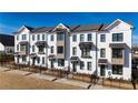 Townhome exterior featuring a painted brick facade, contrasting window trim, and manicured lawn at 629 Silva St # 128, Cumming, GA 30040
