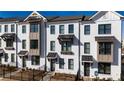 Townhome exterior featuring a painted brick facade, contrasting window trim, and manicured lawn at 629 Silva St # 128, Cumming, GA 30040