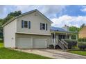 Two-story home with a blue metal roof, a two-car garage, front porch and lawn at 520 White Pines Dr, Dallas, GA 30157