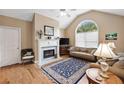 Cozy living room featuring a fireplace, vaulted ceiling, and large arched window at 6355 Autumn View Nw Pt, Acworth, GA 30101