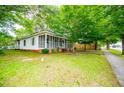 Well-maintained one-story house with screened porch, green lawn, and mature trees at 6539 E Strickland St, Douglasville, GA 30134