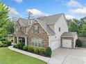 A beautiful house with stone accents and a 3-car garage is set on a well-maintained green lawn at 2767 Nw Magnolia Creek Dr, Kennesaw, GA 30152