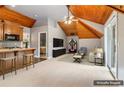 Spacious living area with wood-paneled ceiling, a kitchenette, and entertainment features, virtually staged at 150 Henderson Farm Dr, Woodstock, GA 30188