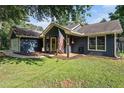 Inviting single-story home showcasing a covered front porch with American flag and a garage at 50 Blackberry Lane, Covington, GA 30016