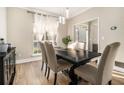 Elegant dining room with modern lighting, hardwood floors, and neutral wall color at 2275 Holly Run Dr, Jonesboro, GA 30236