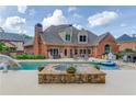 A stunning pool, hot tub and patio area is attached to this brick home, perfect for entertaining or relaxing at 3217 Aberrone Pl, Buford, GA 30519