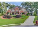 Charming two-story brick home with a well manicured lawn and a long driveway at 3217 Aberrone Pl, Buford, GA 30519