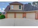 Three car garage with brick accents and neutral colored doors at 3217 Aberrone Pl, Buford, GA 30519