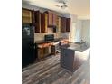Spacious kitchen featuring dark wood cabinets, stainless steel appliances, and an island with a granite countertop at 1900 Old Dogwood, Jonesboro, GA 30238
