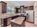 Modern kitchen featuring stainless steel appliances, granite countertops, and dark wood cabinets at 3192 Spicy Cedar Ln, Stonecrest, GA 30038