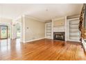 Open-concept living area featuring hardwood floors, a fireplace, and plenty of natural light at 317 Saint Pauls Ct, Stockbridge, GA 30281
