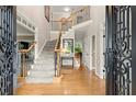Inviting foyer with gleaming hardwood floors, staircase with iron spindles, and access to other rooms at 4300 May Apple Dr, Alpharetta, GA 30005