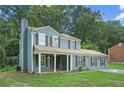 Charming two-story home with blue siding, black shutters, an attached garage, and a covered front porch at 5242 Mccarter Sta, Stone Mountain, GA 30088