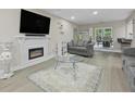 Bright living room with hardwood floors, neutral paint, fireplace, large windows, and open layout to dining area at 5242 Mccarter Sta, Stone Mountain, GA 30088