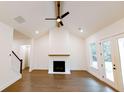 Spacious living room with a fireplace, vaulted ceiling, ceiling fan, and hardwood floors at 6525 Rhett Run, Cumming, GA 30028