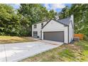 View of the side of a two-story home with an attached garage and a freshly paved driveway at 1841 Surrey Hill Cir, Lawrenceville, GA 30044