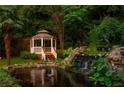 Picturesque backyard featuring a gazebo, tranquil waterfall, pond, and lush greenery at 1865 Mason Mill Rd, Decatur, GA 30033