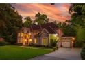 Elegant brick home with manicured lawn, three-car garage, and charming front entrance surrounded by mature trees at 1865 Mason Mill Rd, Decatur, GA 30033