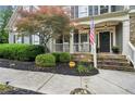Inviting front porch with stone accents, American flag, and well-maintained landscaping at 4275 Green Summers Dr, Cumming, GA 30028