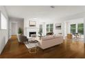 Bright living room featuring hardwood floors, a white fireplace, and a view into office space at 111 Abingdon Way, Sandy Springs, GA 30328