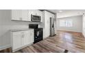 Modern kitchen with white cabinetry, stainless steel appliances, and hardwood floors at 132 Lamar Nw Ave, Atlanta, GA 30314
