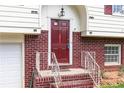Close-up of a home's entryway highlighting a brick facade, red front door, white railings and meticulous landscaping at 2831 Carolyn Se Dr, Smyrna, GA 30080