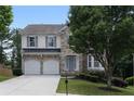 Charming two-story home featuring a stone facade, well-manicured lawn, and a two-car garage at 1722 Preserve Creek Way, Loganville, GA 30052