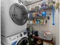 Functional laundry room with stacked washer/dryer and shelving for storage at 2567 Hancock Rd, Social Circle, GA 30025
