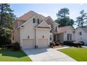 Beautiful two-story home featuring a three-car garage, manicured lawn, and classic architectural details at 4171 Lantern Hill Dr, Dacula, GA 30019