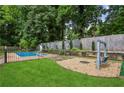A backyard featuring a well-kept lawn, an in-ground pool with a slide, and a swing at 6889 Kingsboro Dr, Lithia Springs, GA 30122