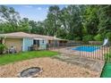 A spacious backyard boasts an in-ground pool, gravel area, and green lawn at 6889 Kingsboro Dr, Lithia Springs, GA 30122