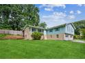 Side view of a well-manicured lawn and a charming split-level home at 6889 Kingsboro Dr, Lithia Springs, GA 30122