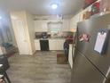 View of kitchen featuring white cabinetry, a stainless steel refrigerator, and laminate flooring at 8951 Stonebridge Blvd, Douglasville, GA 30134