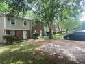 Exterior view of townhomes with lawn and mature trees, showing a residential neighborhood at 8957 Stonebridge Blvd, Douglasville, GA 30134