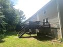 The back of the townhomes features a wooden deck and stairs leading to a grassy area at 8957 Stonebridge Blvd, Douglasville, GA 30134