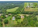 A beautiful aerial view of a home surrounded by lush greenery and a nearby meadow, creating a serene and private setting at 4444 Cannon Sw Rd, Loganville, GA 30052