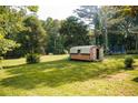 Spacious, green backyard featuring a storage shed, trampoline, and mature trees at 4565 Deerfield Dr, Cumming, GA 30028